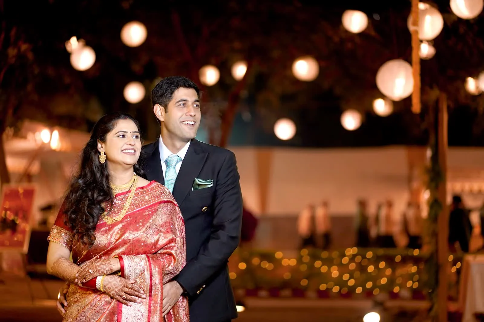 Couple under hanging lanterns at an evening wedding reception
