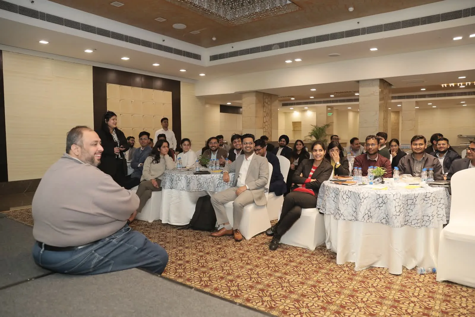 Seated audience listening to a speaker at a Delhi banquet hall conference