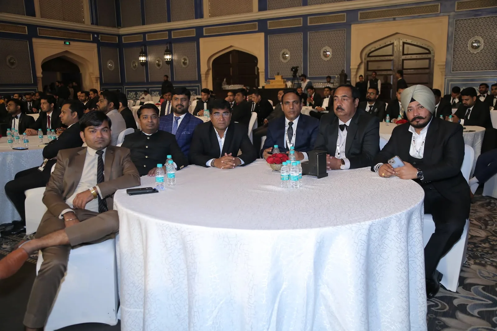 Corporate delegates seated at round tables in a Delhi banquet hall
