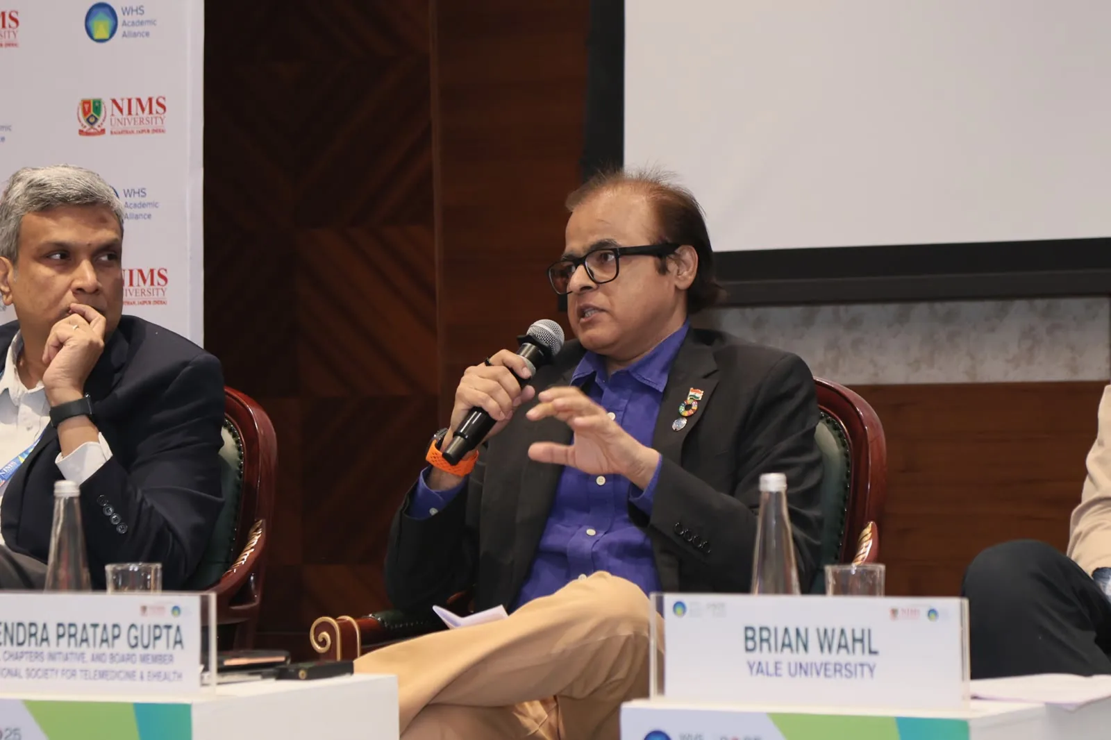 Panel discussion with speakers and microphones at a Delhi seminar