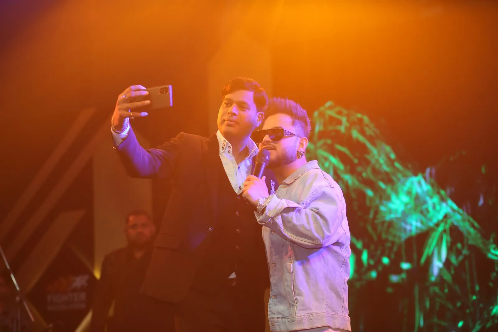 Performer and crowd under stage lighting during an evening celebration