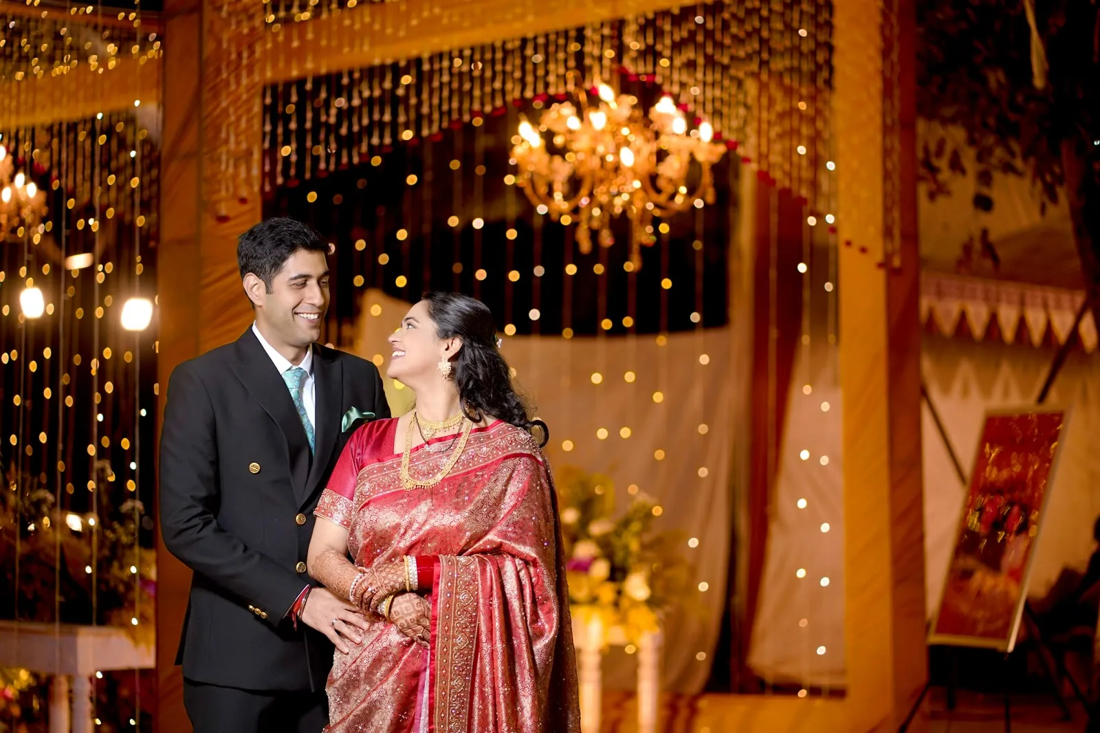 Couple at a sagan celebration under warm lights in Delhi