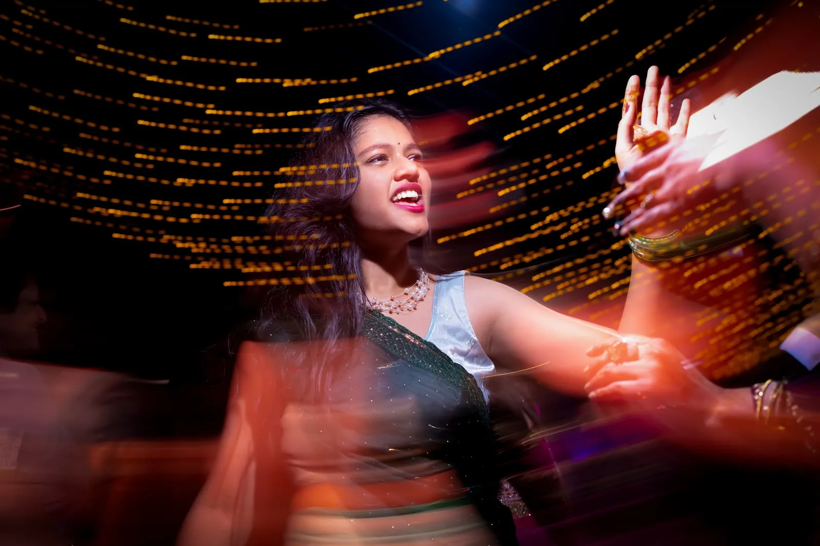 Guests dancing under fairy lights at a sangeet celebration